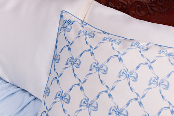 Pillow with blue bow pattern on a bed