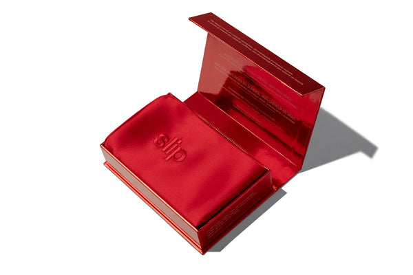 Opened red silk pillowcase packaging on a white background