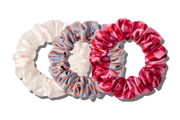 A set of large scrunchies in various colors including blue, red, pink and white on a white background.
