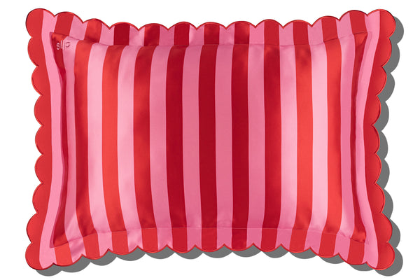 A striped pink slip silk pillowcase with a scalloped edge on a white background.