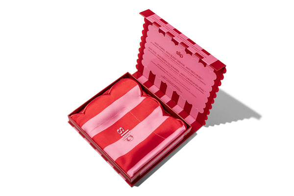 A striped pink slip silk pillowcase box, opened on a white background.