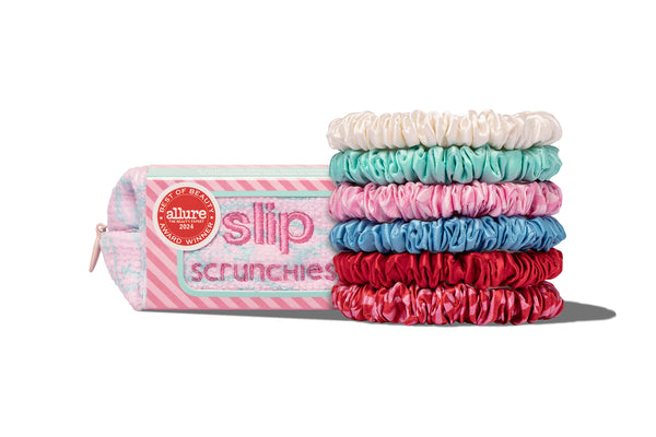 A set of colorful silk skinny scrunchies in sundown, bianca, ocean, frutti, turquoise, and sunshade shades, displayed with a complimentary pouch.