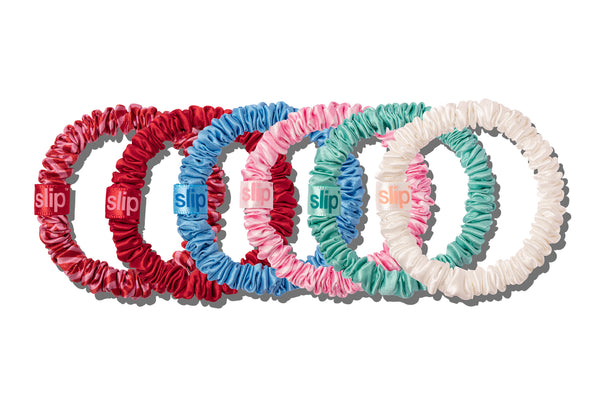 A set of colorful slip silk skinny scrunchies on a white background.