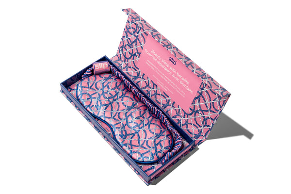 A slip pure silk sleep mask in open packaging with a blue and pink nautical ropes pattern on a white background.