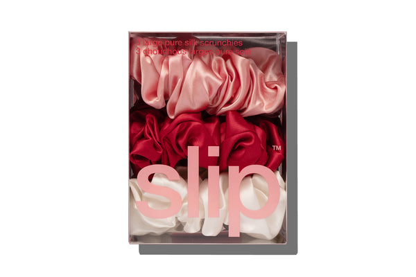Box of slip scrunchies with red, pink, and white scrunchies on a white background