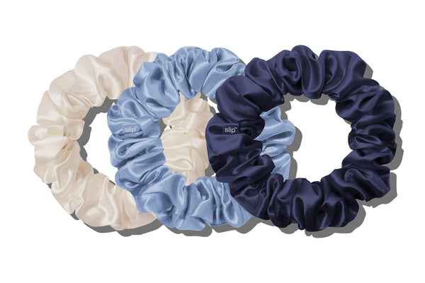 Three silk large scrunchies in white, blue, and navy on a white background