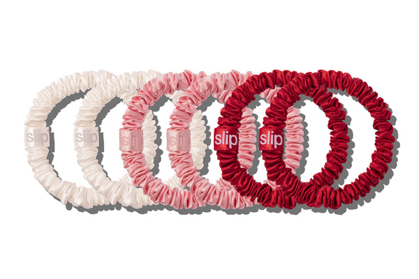 Set of red, pink, and white hair scrunchies with 'slip' branding on a white background.