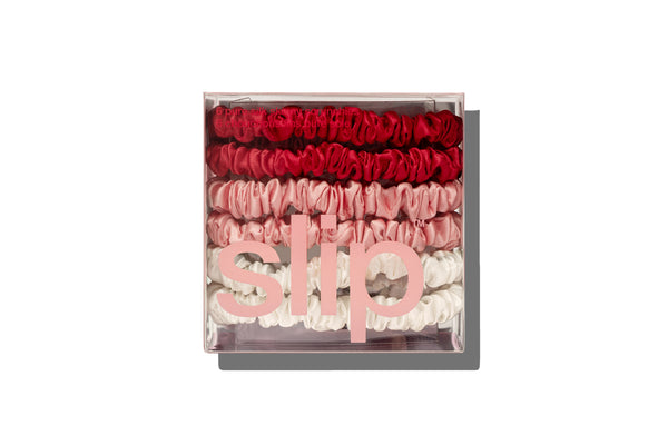 Set of red, pink and white hair ties in a clear box.