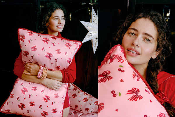 A split-screen lifestyle photo showing a woman holding a pink pillow with a red cherry and bow pattern. The left panel shows her holding the upright pillow, while the right panel is a close-up of the pillow's patterned fabric with lace trim.
