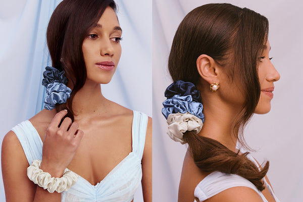 Woman with hair styled with large silk scrunchies on a plain background