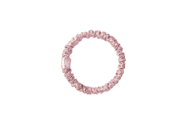Pink silk skinny scrunchie on a white background