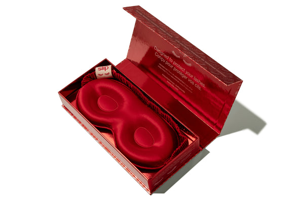 Red silk contour sleep mask in packaging on a white background
