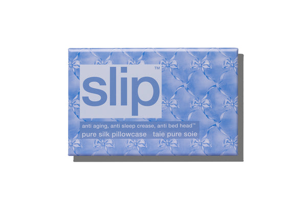 Box of slip pure silk pillowcase with blue bow design on a white background