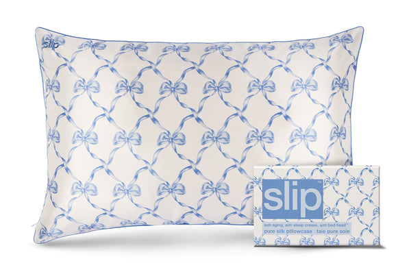 Silk pillowcase with blue bow pattern and packaging labeled 'slip' on a white background