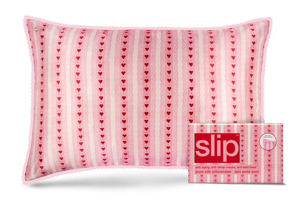 Pink pillowcase with heart pattern and packaging labeled 'slip' on a white background