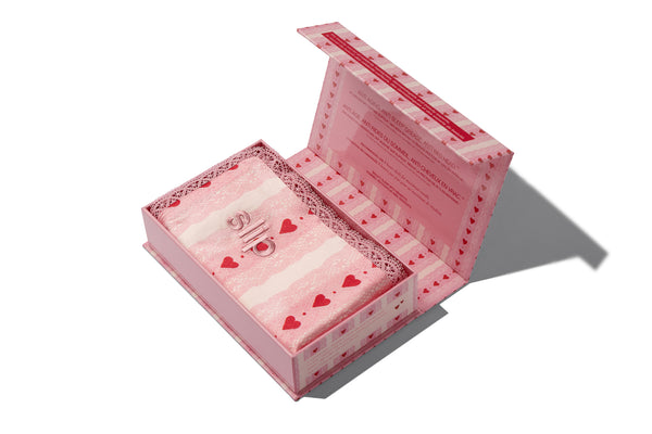Open silk pillowcase box with hearts on a white background