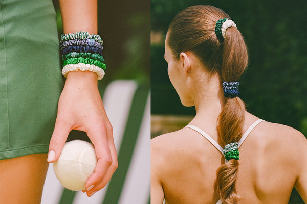 Person holding a ball with green and blue silk scrunchies on wrist and hair, outdoors.