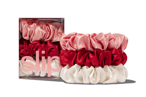 Set of red, pink, and white silk scrunchies in a clear box with 'slip' branding.