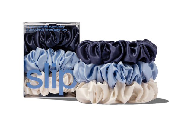 Set of blue, white, and navy large scrunchies with packaging labeled 'slip' on a white background.