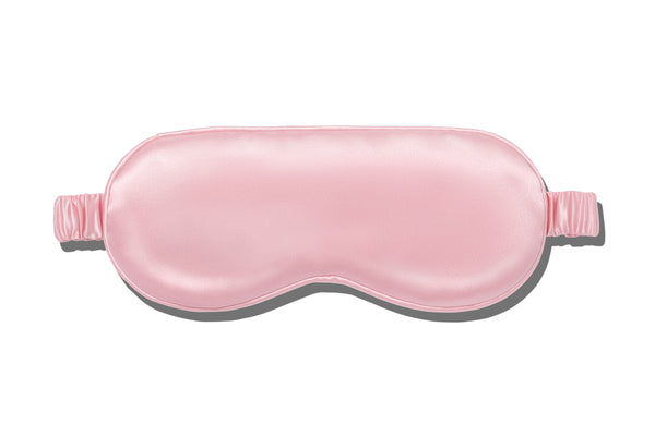 A pink slip silk sleep mask on a white background.