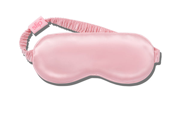 A pink slip silk sleep mask on a white background.